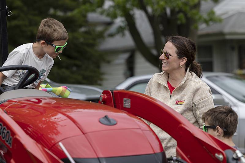 Jill DeRycke of Birkey’s of Prophetstown helps students up onto a tractor Thursday, May 9, 2024 at Farmapalooza.