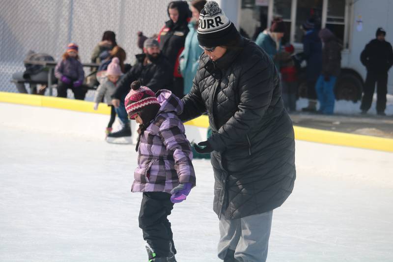 Maria Morrow (right) walks across the ice rink with her daughter Rose Morrow, 5, (left) during the DeKalb Park District's seventh annual Polar Palooza held Saturday, Feb. 4, 2023.