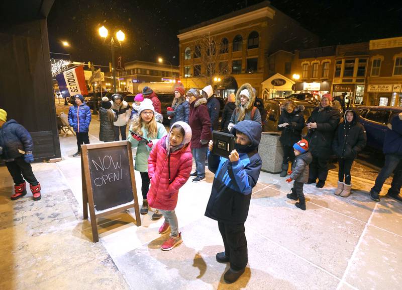Visitors watch performers from the Beth Fowler Dance Company dance in the window of Pizza Beer Whiskey Friday, Nov. 18, 2022, during the Sycamore Chamber of Commerce's annual Moonlight Magic event in downtown Sycamore.