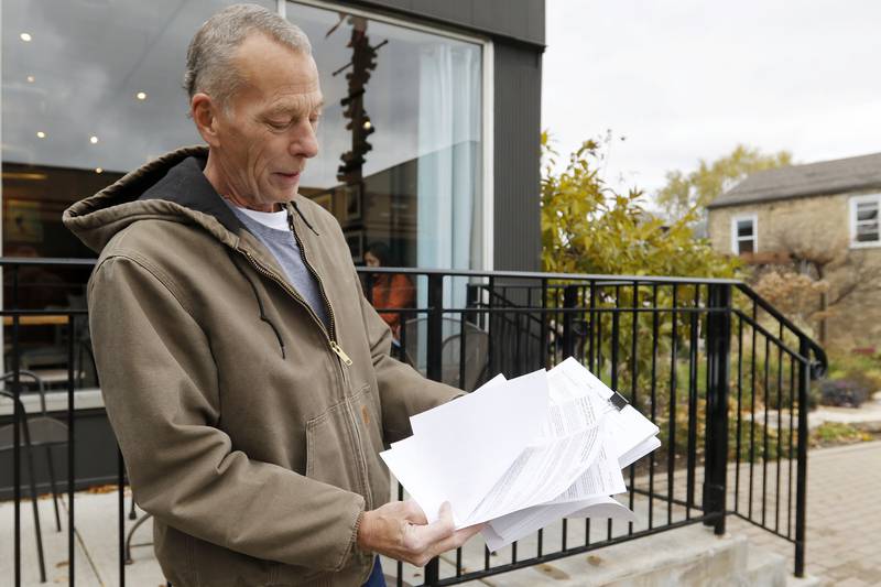 Kenneth Dill, a condo owner at the Greens of Irish Prairie, shows legal documents connected to the sale of the complex on Thursday, Nov. 11, 2021, in McHenry