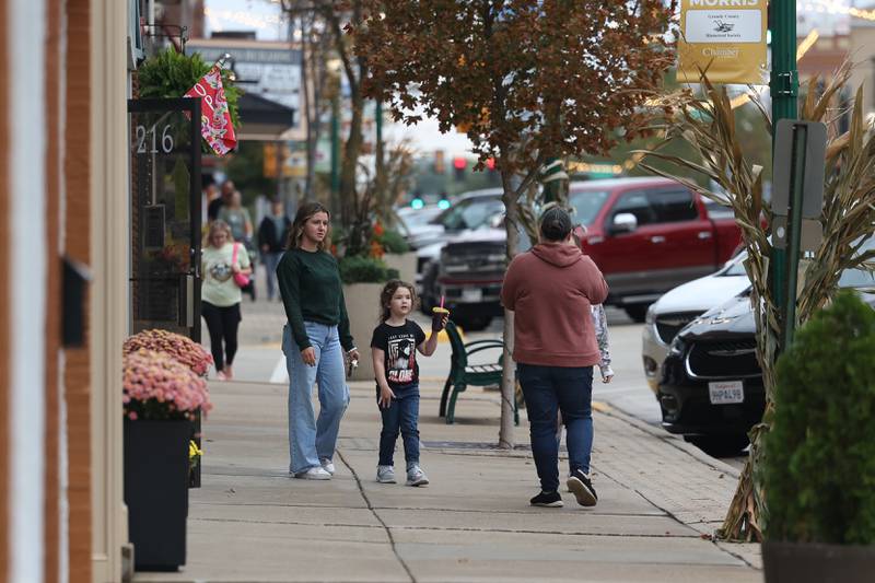 A family walks down Liberty Street at the 75th Annual Grundy County Corn Festival on Saturday, Sept. 28, 2024 in downtown Morris.