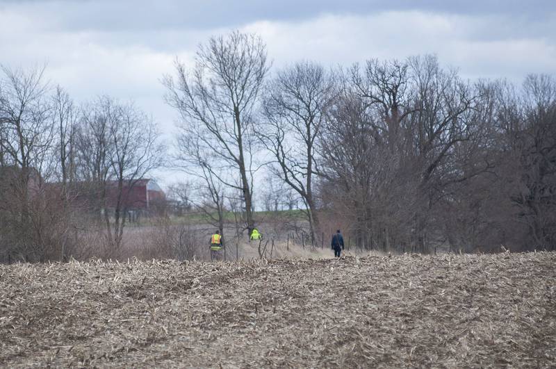 Investigators search a field near the scene of a fatal shooting Monday, April 18, 2022 north of Sterling.