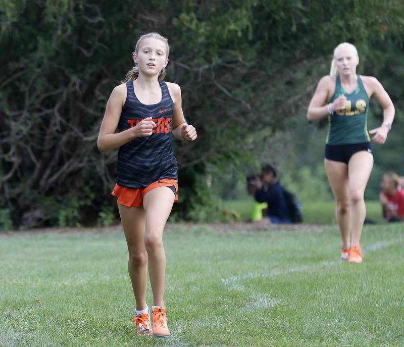 Crystal Lake Central’s Brynn Matthaei leads Crystal Lake South’s Abby Machesky as they compete in the girls race of the McHenry County Cross Country Meet Saturday, August 27, 2022, at Emricson Park in Woodstock.