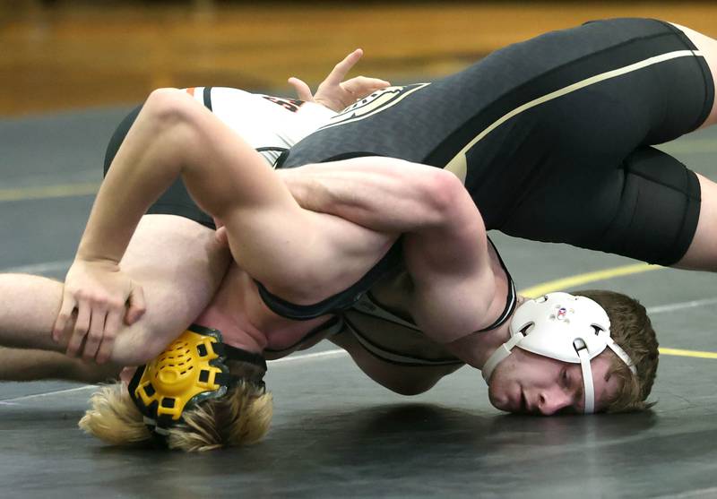Kaneland’s Jack Gruber (right) scores points against Sycamore’s Logan Sandfox during their 144 pound match Thursday, Jan. 9, 2025, at Sycamore High School.