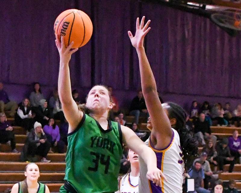York's Olivia Silkaitis (34) makes a basket on Tuesday Dec. 3, 2024, during the game while being defended by Downers Grove North's Elizabeth Murphy held at Downers Grove North.