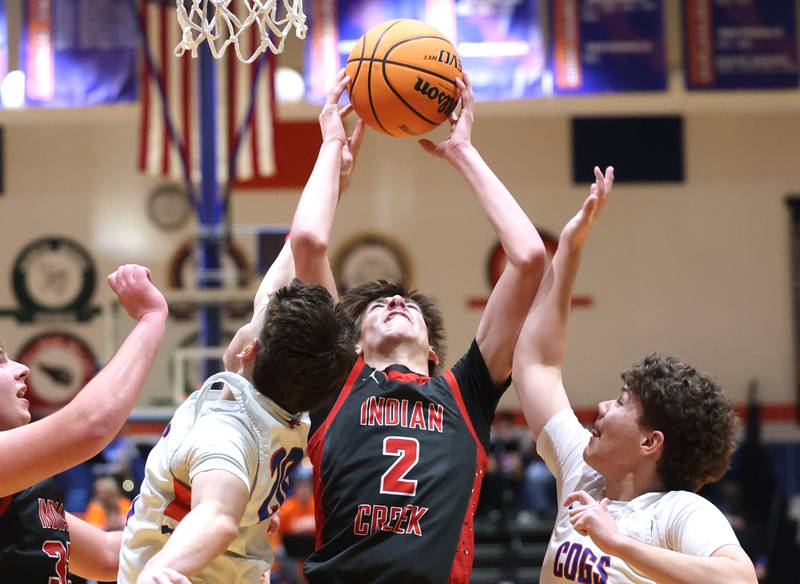 Indian Creek's Jason Brewer grabs a rebound between Genoa-Kingston's Jaiden Lee (left) and Cameron Gunderson during their game Friday, Jan. 2, 2026, at Genoa Kingston High School.