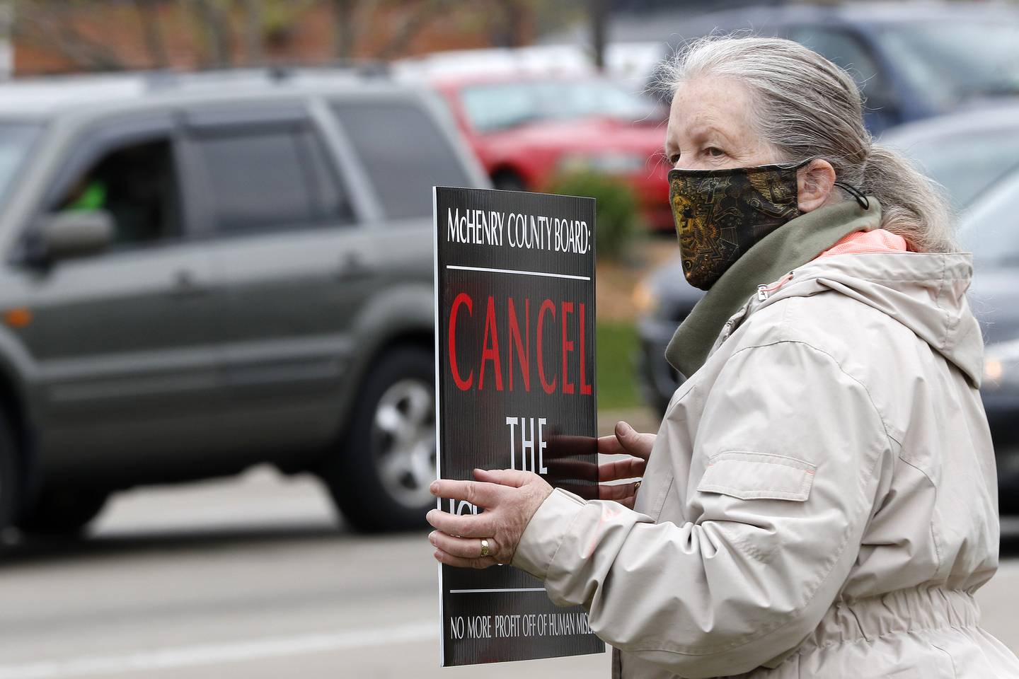 Sue Rekenthaler of Richmond stands near the road for passersby to see her sign in favor of canceling the county's contract with U.S. Immigration and Customs Enforcement during a rally at the intersection of Front and West Elm streets on Saturday, April 24, 2021, in McHenry. "There's got to be a more humane way," Rekenthaler said, adding "it's not solving the problem, but it's a start." Rekenthaler also added that "If we still have to have immigration and custom enforcement, to look into cheaper ways of detaining people. (Canceling the ICE contract) will discontinue paying some of the county's bills and will show our elected officials we do not want to make money off of a flawed system."