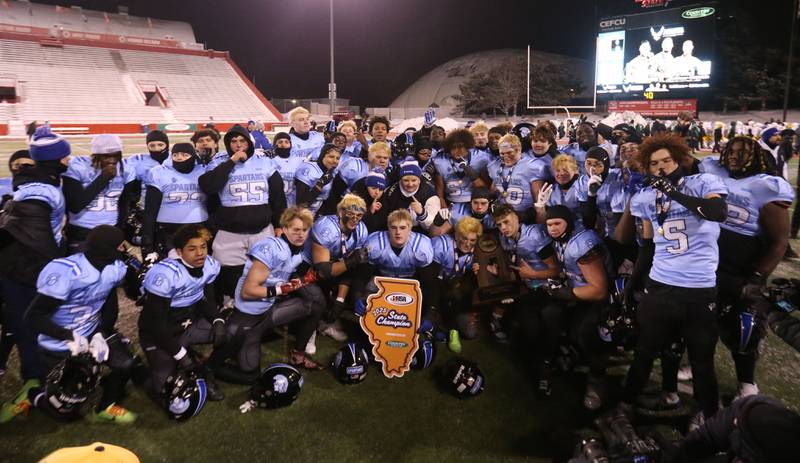 Members of the St. Francis football team pose with the Class 5A State championship trophy on Tuesday, Dec. 2, 2025 in Hancock Stadium at Illinois State University in Normal.