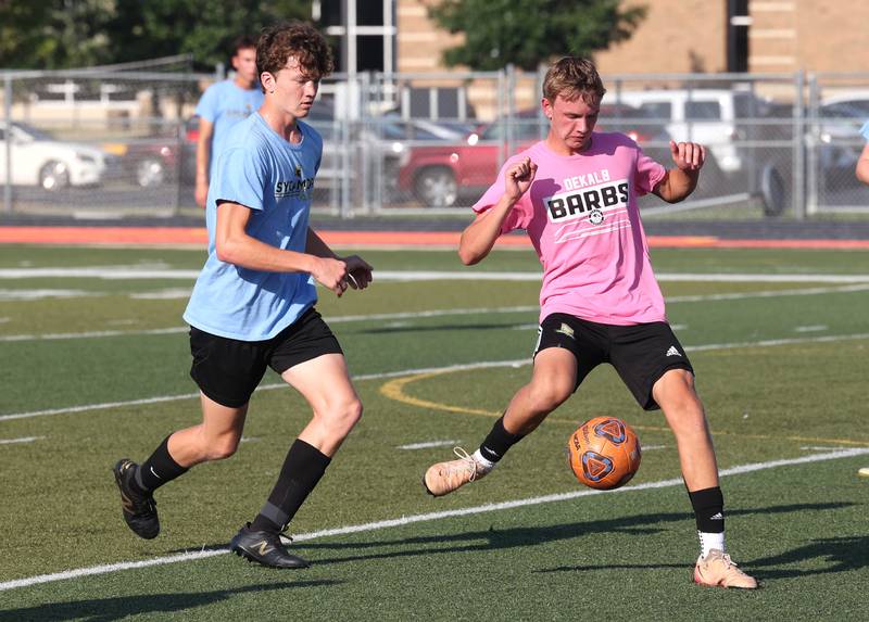 A DeKalb player kicks the ball up field in front of a Sycamore player Monday, July 14, 2025, during a summer boys soccer friendly at DeKalb High School.