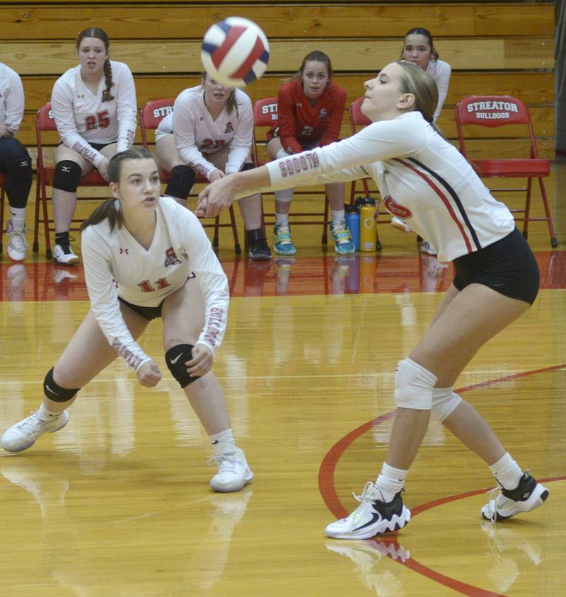 Streator’s Kora Lane looks on as team mate Shaley Grosbeak returns a serve against Sterling during the first match Tuesday at Streator.