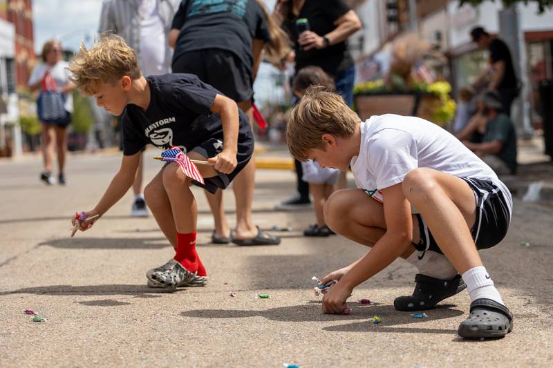 (from left) Cannon Shabaka and brother Knox grab on street on Sunday, Aug 31, 2025 at the Labor Day parade on Main Street in Streator.