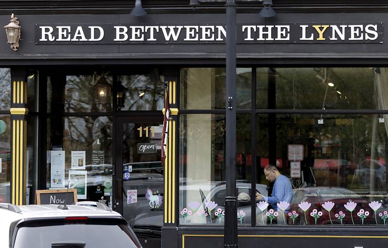 A man reads and enjoys his coffee at Read Between The Lynes on Wednesday, April 19, 2023, as spring like weather returns after a snowy start to the week.
