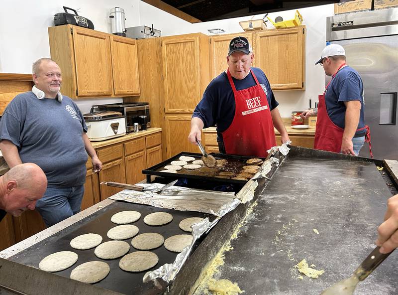 Mt. Morris Fire Chief Rob Hough cooks sausage patties on the grill with his fellow firefighters and volunteers on Friday morning, July 4, 2025 cooking breakfast at the fire station. The event is an annual fundraiser for the fire protection district.