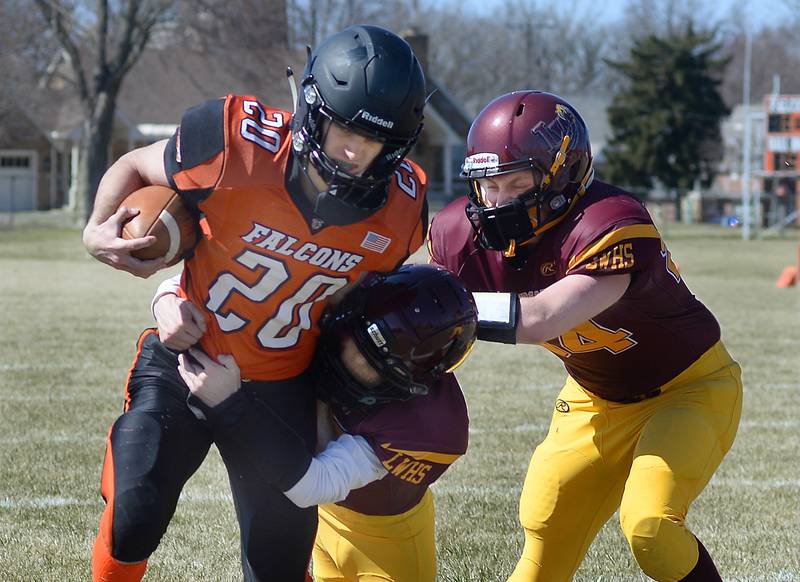 FCW's Jesse Simpson (20) fights a pair of Lowpoint-Washburn/Henry-Senachwine tacklers last spring.