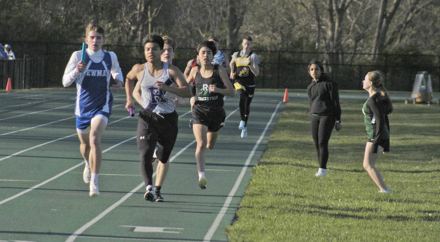 Newman's Cody McBride pushes for first place during the first lap of the boys 4x800 relay at the Rock Falls Rocket Invite at Hinders Field on Friday, April 19, 2024.