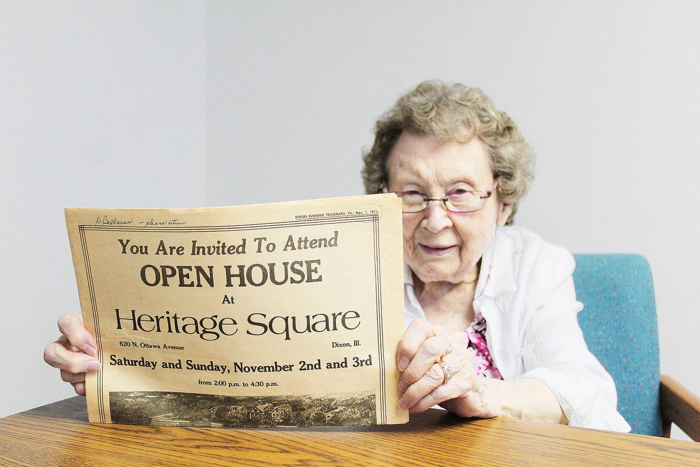 Dorothy Bellows holds an advertisement from the Dixon Telegraph about Heritage Square's open house celebration from its opening in November 1974. Bellows was one of its original employees: she served as activity director for 24 years, and has been a resident since 2020.