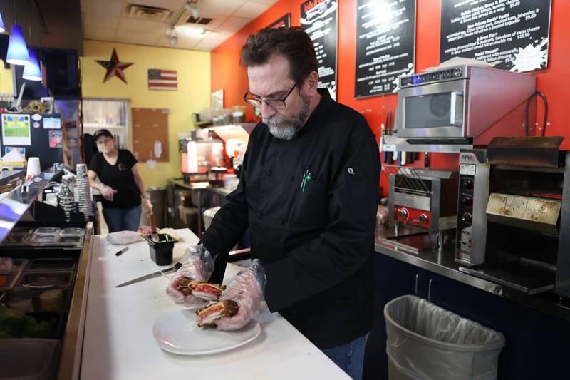 Tom Grotovsky, owner of The Curator’s Cafe, makes a signature sandwich on Friday, Jan. 5th, 2024 in Joliet. Tom rebranded his Great American Bagel Joliet location to The Curator’s Cafe at the start of the new year.