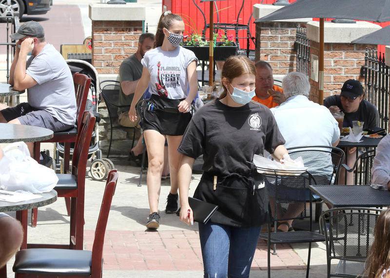 Waitresses take care of diners having lunch on the patio at PJ's Courthouse Tavern in Sycamore Friday. Outdoor dining at restaurants and other businesses were able to open for the first time Friday since being shut down due to the pandemic.
