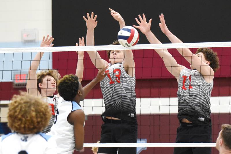 Bradley-Bourbonnais' Timmy Pfrommer (13) and Jacob Berns (11) block a hit from Kankakee's Jamon Barlow during the All-City boys volleyball game at Kankakee Thursday, April 10, 2025.