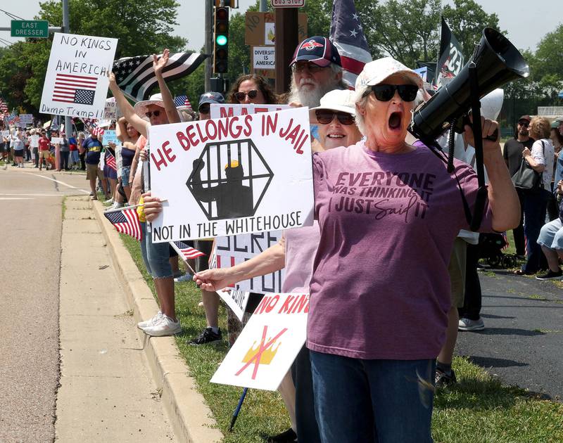 Waunita Rosenbaum, from Sycamore, yells slogans along Sycamore Road Saturday, June 14, 2025, during a No Kings rally at Hopkins Park in DeKalb. The group was protesting the policies of President Donald Trump and his administration.