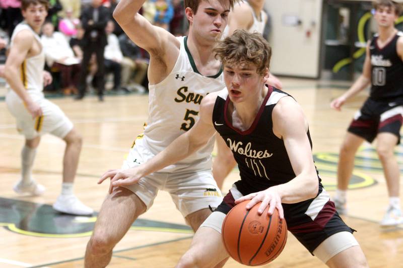Prairie Ridge’s James Muse, front, moves the Ball as Crystal Lake South’s Brady Schroeder defends in varsity boys basketball at Crystal Lake South Friday night.