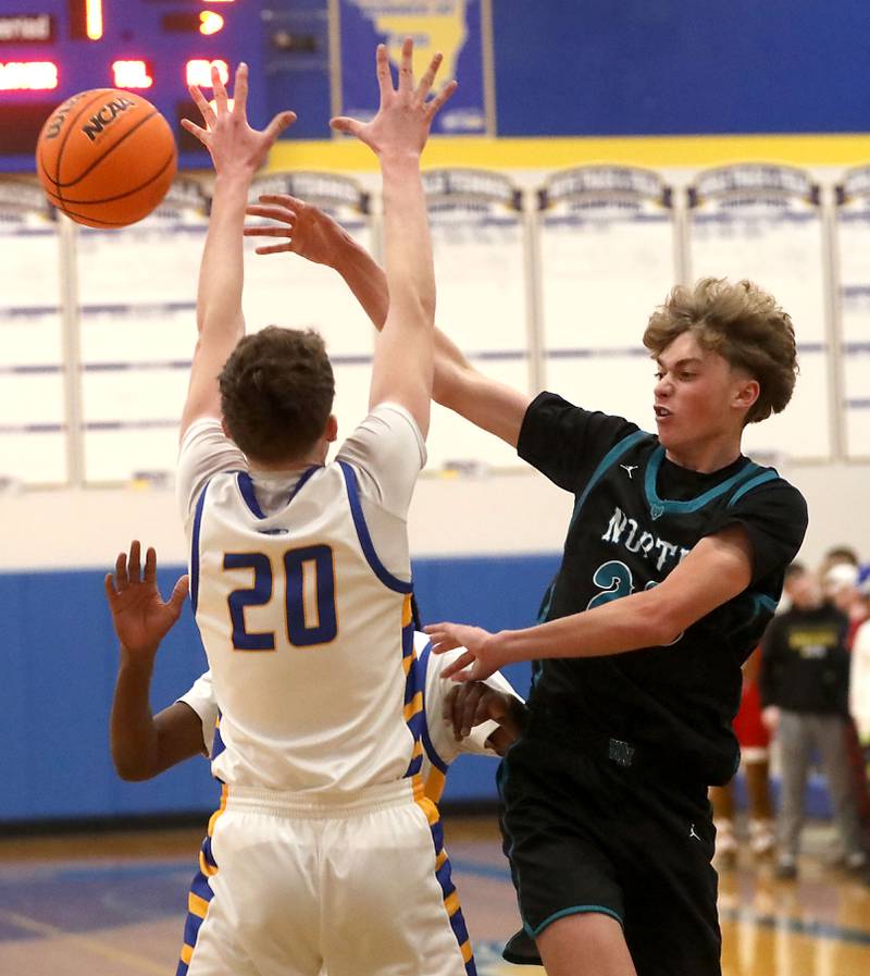 Woodstock North's Ethan Richardson (right) passes the ball as he is defended by Johnsburg's Josh Kaunas during a Kishwaukee River Conference boys basketball game on Monday, Dec. 15, 2025, at Johnsburg High School.