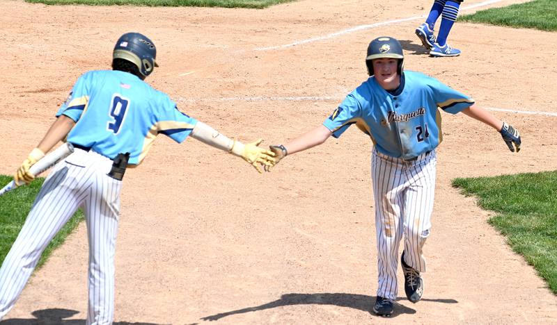 Marquette's (24) tags his teammate after scoring a run against Newman.