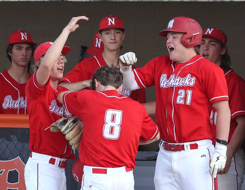 Naperville Central's Michael Page (middle) is congratulated by teammates after scoring a run Monday, April 28, 2025, during their game at DeKalb High School.