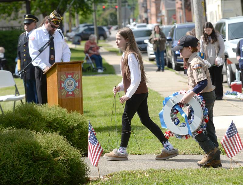 Veteran Matt Alford speaks as Girl Scout Lauren Hickman and a Boy Scout get ready to place a wreath during the Memorial Day service at Riverside Cemetery in Oregon on Monday, May 26, 2025.