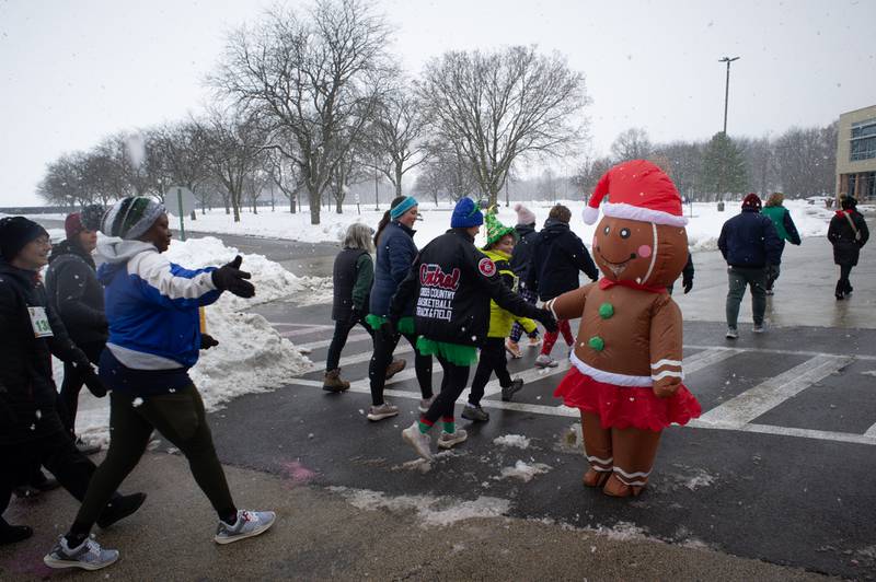 Emma Finnegan, 11, of Manteno, greets walkers in her gingerbread man costume at the 35th annual Jingle Bell Run at Kankakee Community College on Sunday, December 7, 2025.