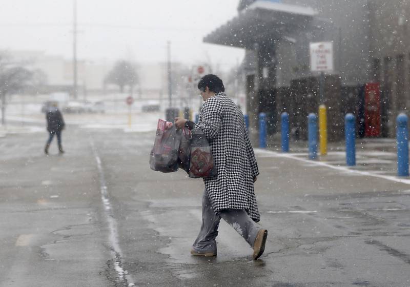 A shopper leaves Walmart on Wednesday, Feb. 12, 2025, in Johnsburg as a winter storm starts to bring heavy snow to the McHenry County area.