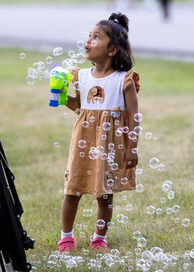 Ria, 3, plays with a bubble toy before the “July 4th Fireworks” at Langum Park in St. Charles on Friday, July 4, 2025.