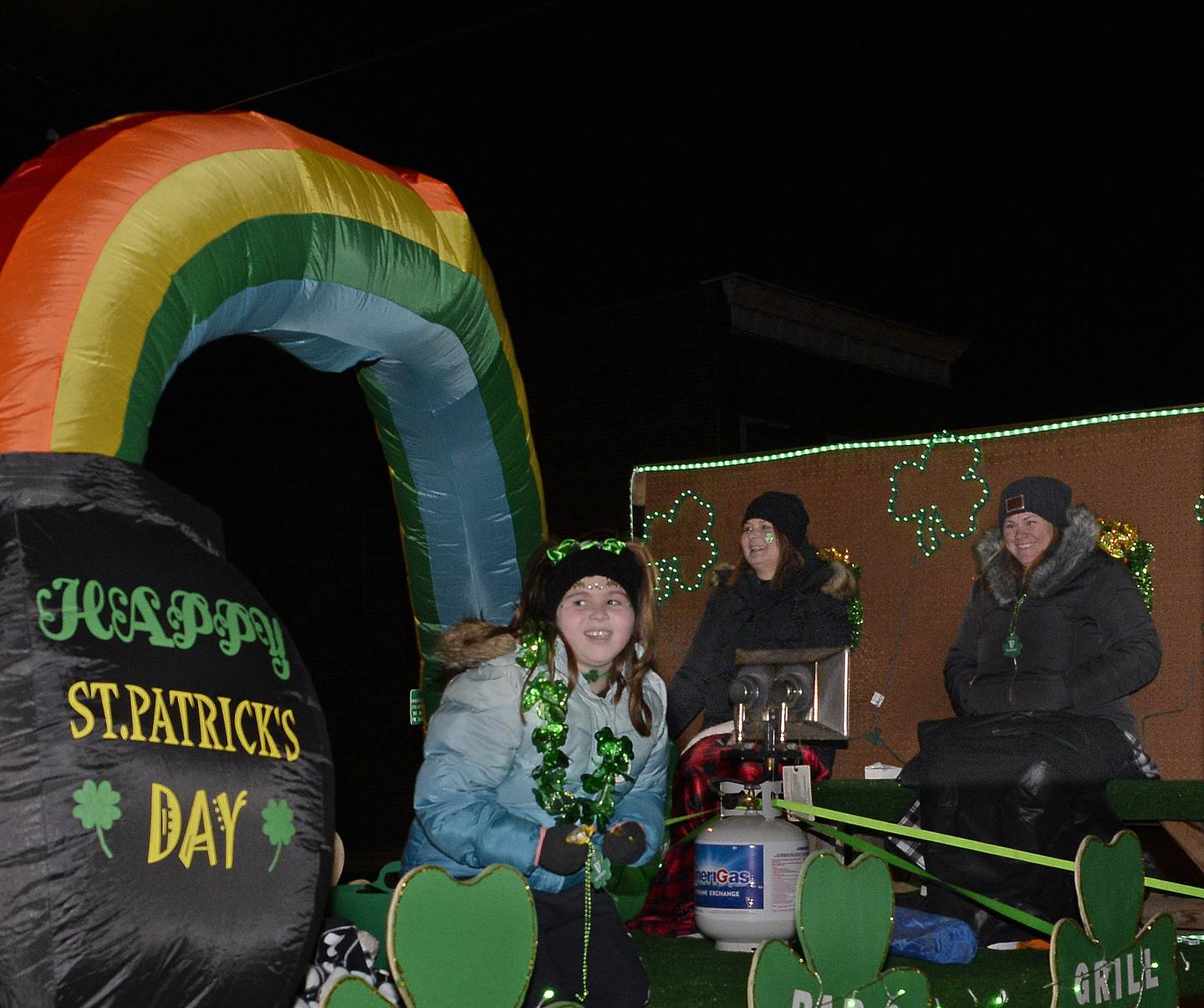 Those riding on the Ziggy’s float work to stay warm during the lighted St Patrick’s Day Parade Saturday, March 12, 2022, in Marseilles.