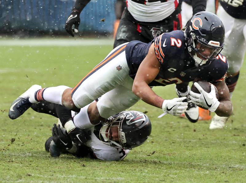 Chicago Bears wide receiver DJ Moore dives for extra yardage as he is brought down by Atlanta Falcons safety Jessie Bates III during their game Sunday, Dec. 31, 2023, at Soldier Field in Chicago.