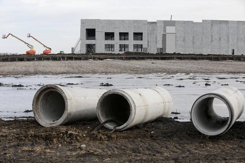 Concrete drainage pipes sit in a muddy field Dec. 28 as construction continues on a warehouse spanning nearly 1 million square feet in Joliet. Zoning board members are questioning whether the numbers of staffing agencies coming to Joliet contribute to temporary jobs at the warehouses being built in Joliet.