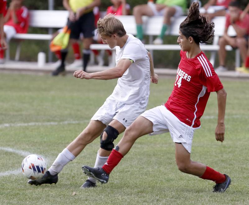 Crystal Lake South's Nolan Getzinger kicks the ball towards the goal as he is defended by Dundee-Crown's Sebastian Sanchez during a Fox Valley Conference soccer match Tuesday, Sept. 5, 2023, at Dundee-Crown High School in Carpentersville.