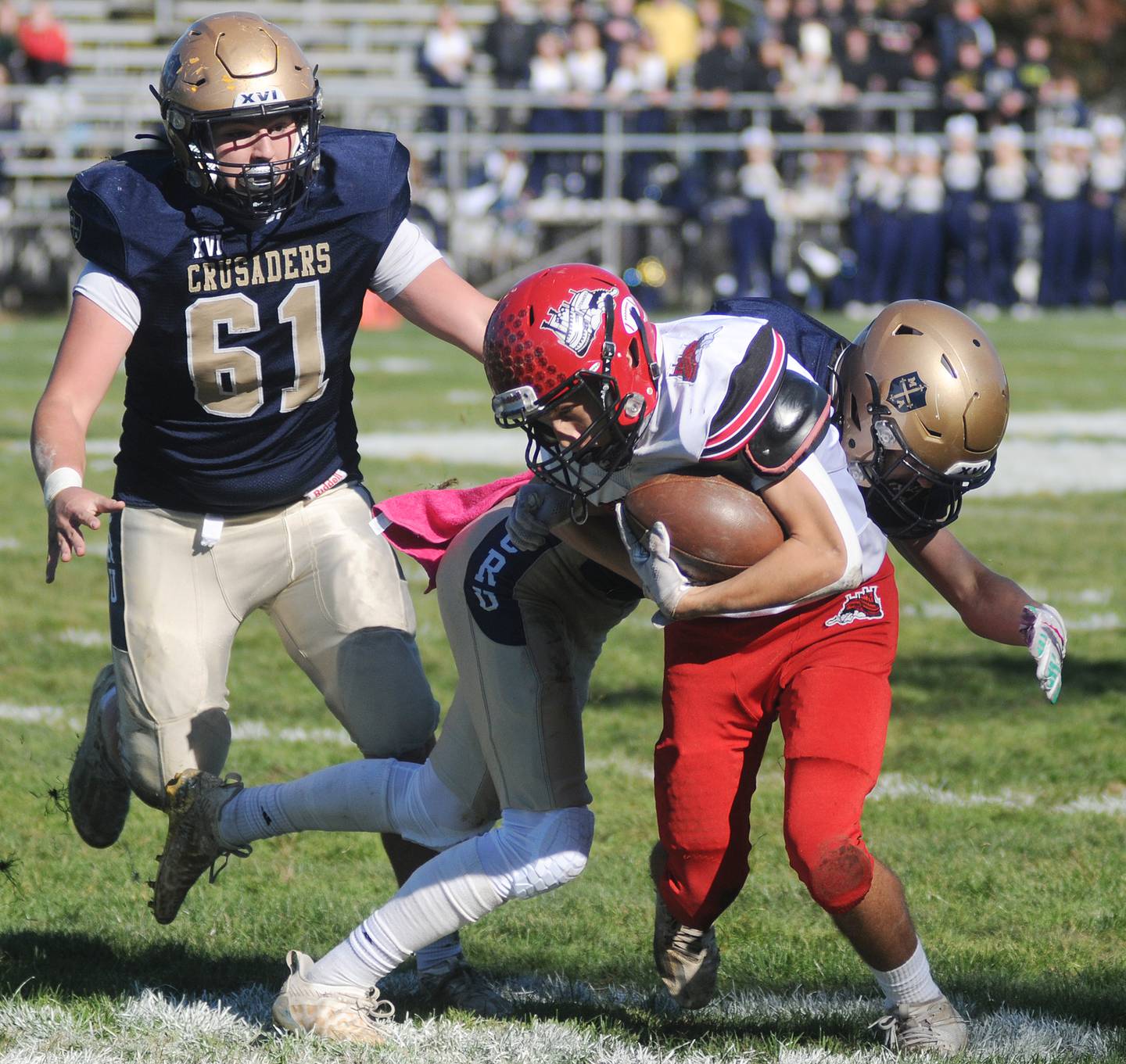Marquette's Logan Nelson (42) tackles Fulton's Ryan Eads as teammate Beau Ewers closes in during the 1A playoff game at Gould Stadium on Saturday, Nov. 6, 2021.