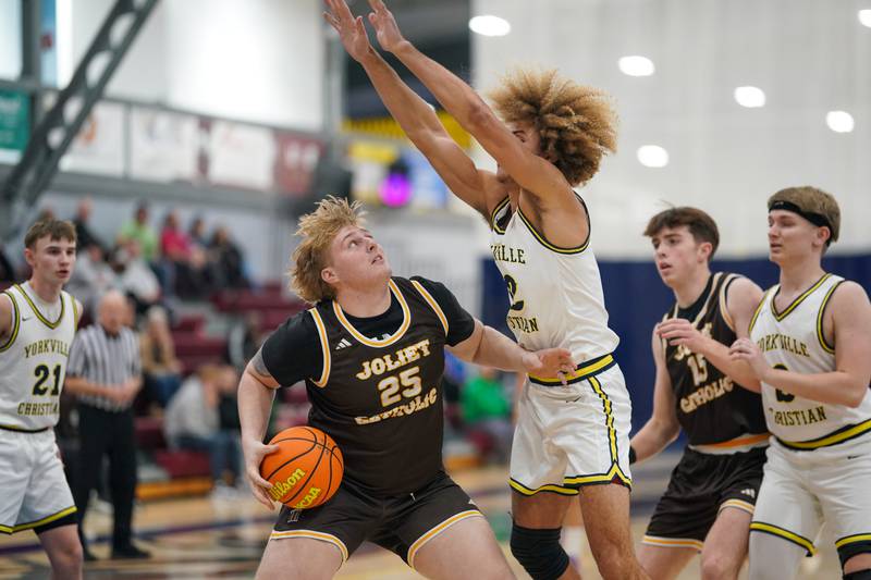 Joliet Catholic's Michael Lynch (25) plays the ball in the post against Yorkville Christian's Noah Aguado (22) during a basketball game at Yorkville Christian High School on Monday, January 13, 2025.
