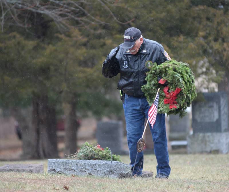 Veteran John Tuttle of Oregon salutes after placing a wreath at a veteran's grave during the Wreaths Across America event at Daysville Cemetery on Saturday Dec. 14, 2024.