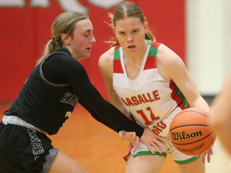 Kaneland's Alexis Schueler knocks the ball out of L-P's Elizabeth Sines hands on Friday, Dec. 8, 2023 in Sellett Gymnasium at L-P High School.