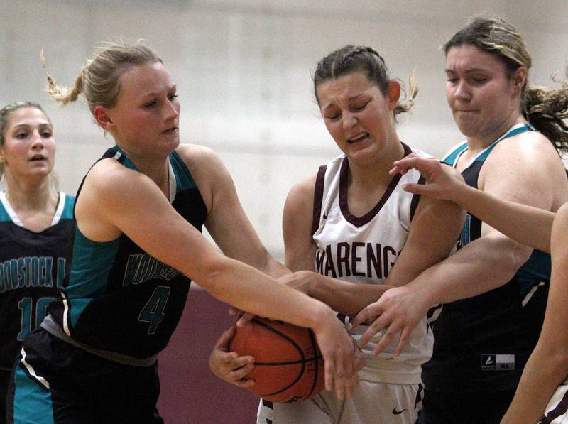 Marengo’s Gabby Gieseke, center, fights for possession of a rebound against Woodstock North’s Caylin Stevens, left, and Ashley Janeczko in varsity girls basketball at Marengo Tuesday evening.
