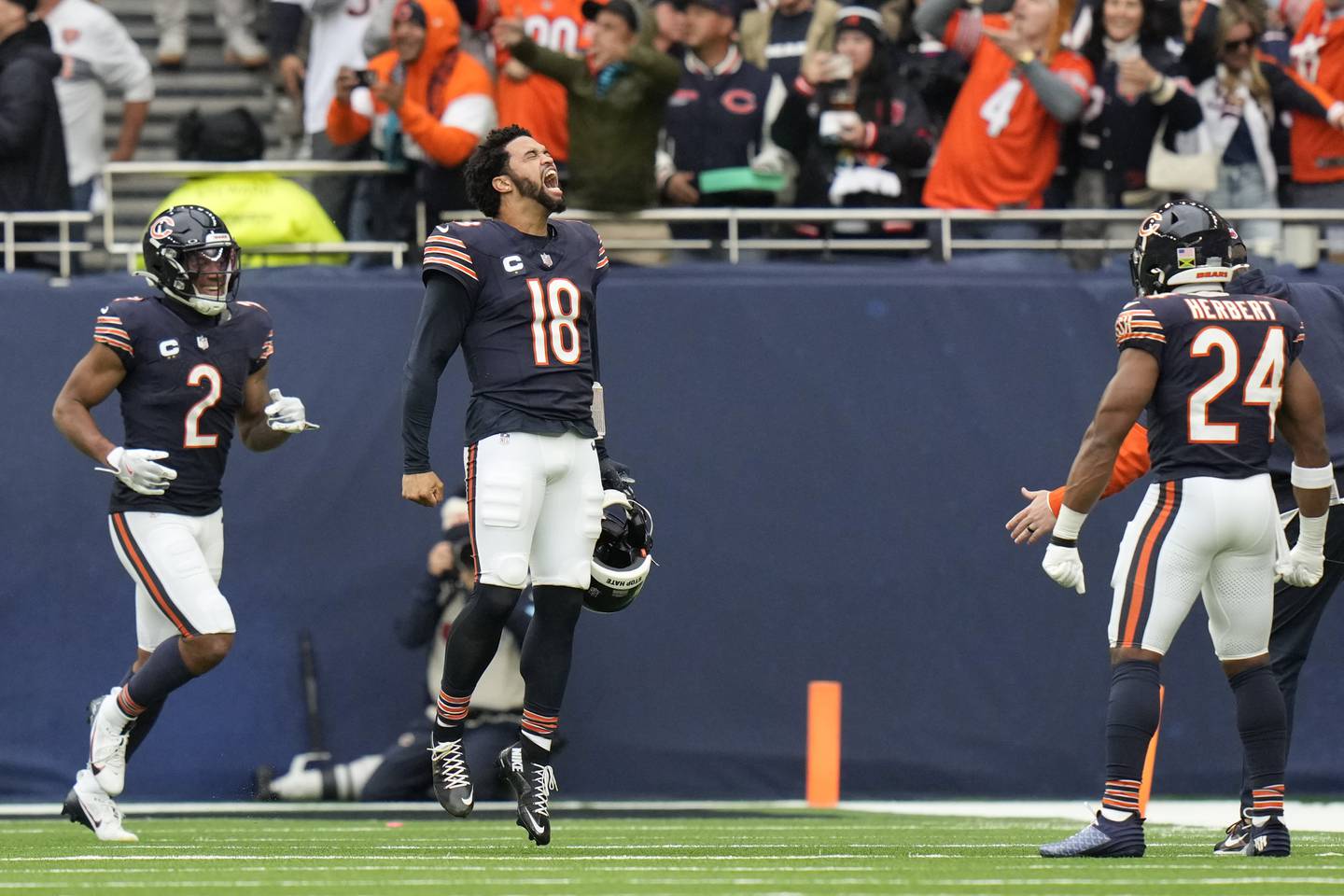 Chicago Bears quarterback Caleb Williams (18) celebrates after Bears wide receiver Keenan Allen (13) scored his side's third touchdown during the third quarter of an NFL football game at the Tottenham Hotspur stadium between the Jacksonville Jaguars and Chicago Bears in London, Sunday, Oct. 13, 2024.