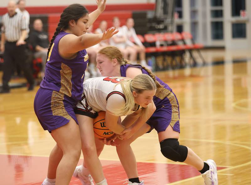 Hall's Caroline Morris hangs on to the ball as Mendota's Emily Diaz and Emily Sondgeroth force a jump ball on Monday, Dec. 1, 2025 at Hall High School.