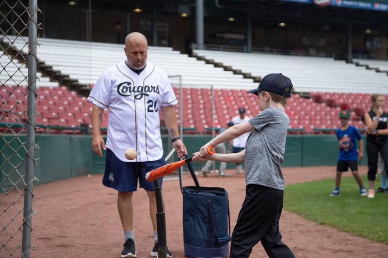 Abe Richardson (7) of Plainfield hits a ball off a tee at the hitting station of the Kane County Cougar's Youth Clinic at Northwestern Medicine Field on Saturday, July 16, 2022.