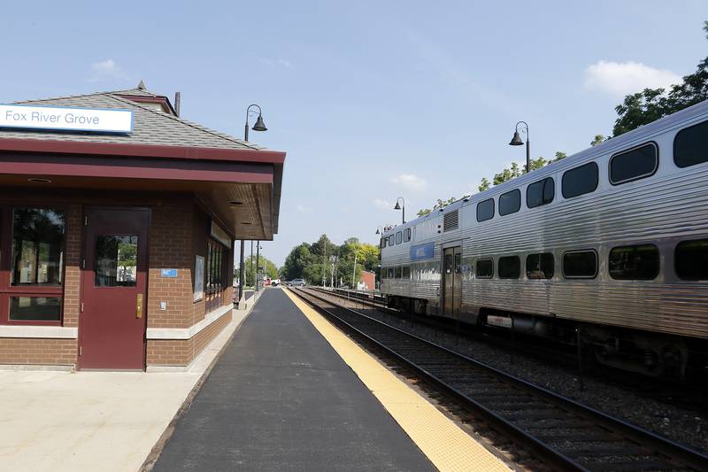 Metra commuters arrive on the platform from Chicago at Fox River Grove on Tuesday, July 6, 2021.