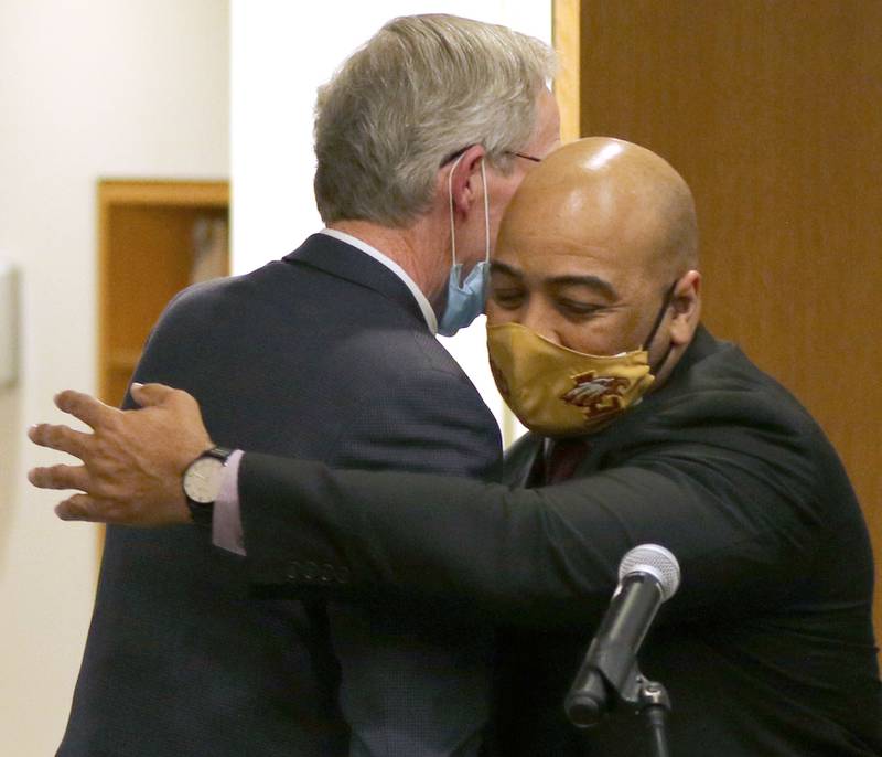 DeKalb City Manager Bill Nicklas hugs Illinois State Police Col. David Byrd during the City Council meeting Monday after announcing Byrd was the citizen-led search committee’s choice to be the next police chief of DeKalb.