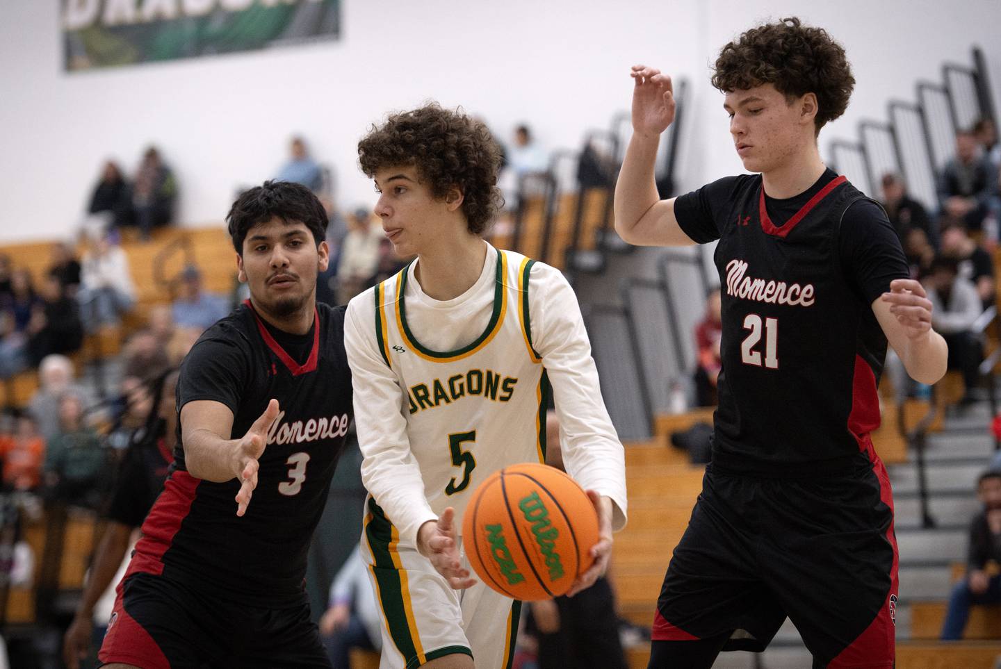 Grant Park's Shawn Kveck, center, looks to pass as Momence's Eddie Ferriera, left, and Tommy Rounds, right, guard in a game on Friday, January 16, 2026.