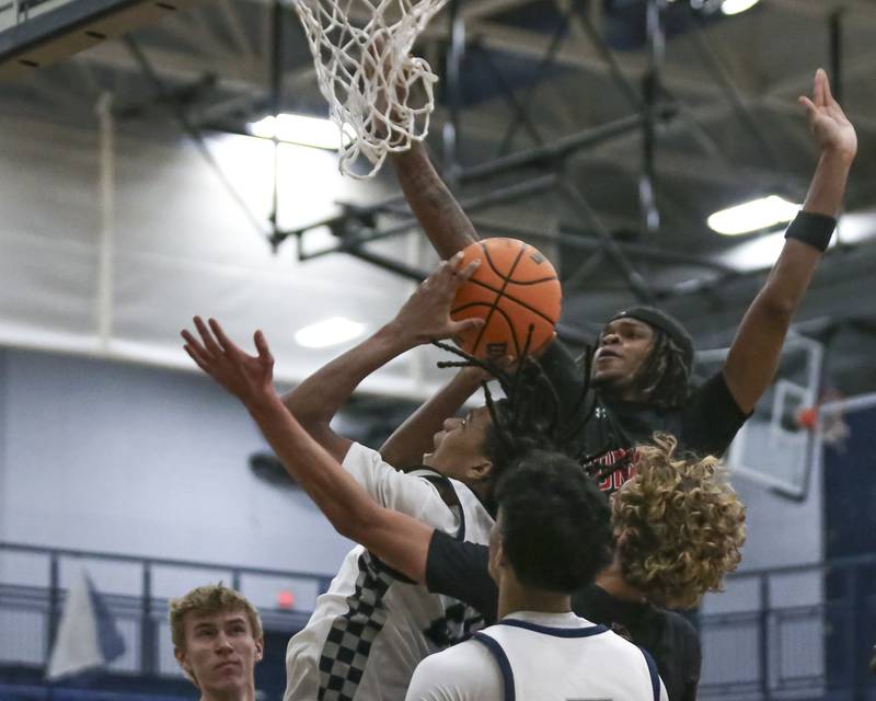 Oswego East's Dshaun Bolden (24) goes back up after grabbing a rebound during their basketball game between Yorkville at Oswego East. Friday, Dec 19, 2025 in Oswego.