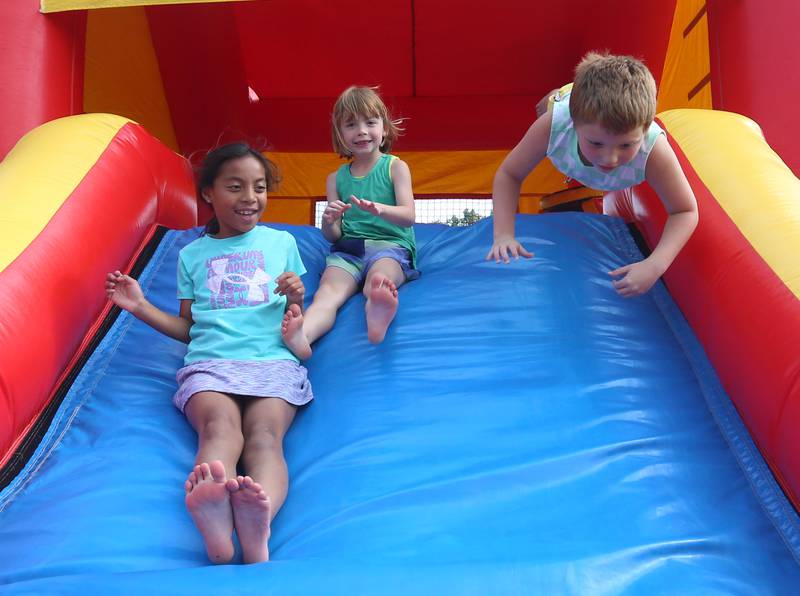 (From left) Eliana Smith, Hendrix Chapin and Minka Chapin slide down a bounce house during National Night Out on Tuesday, Aug. 5, 2025 in Oglesby. Oglebsy Police, Fire and EMS along with Utica Fire, Illinois State Police and OSF Lifeflight helicopter also attended. The event featured food, foam machine, bounce house, games and more. National Night Out is an annual community policing campaign held on the first Tuesday of August to create police-community partnerships and build safer neighborhoods