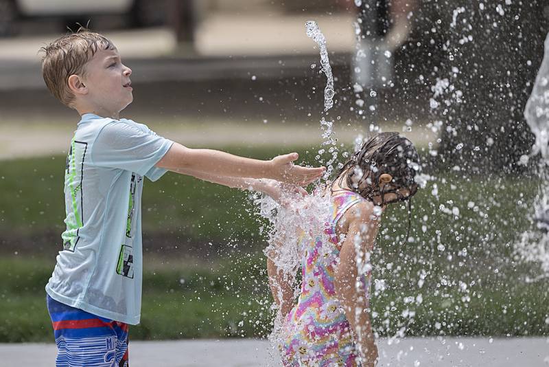 Greyson Ebersole, 7, reaches for the water at Sterling’s new Grandon Civic Center splash pad Wednesday, May 31, 2023.